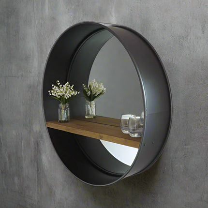 Large round industrial metal wall mirror with wood shelf.