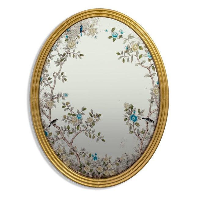Decorative oval mirror with floral and bird design in a gold frame on a white background - Elderflower Lane