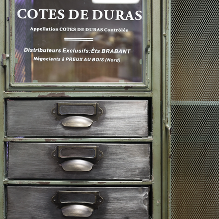 Vintage wooden cabinet with glass panel displaying '1879 COTES DE DURAS' branding.