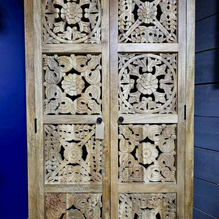 Tall ornate carved natural wood storage cupboard