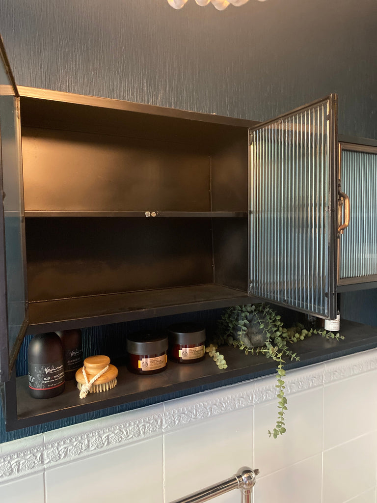 Black metal industrial wide wall storage cabinet with ribbed glass double doors.